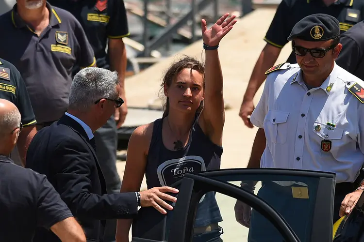 Carola Rackete: a jovem alemã capitã do barco Sea-Watch é escoltada pela polícia local após ter ancorado em Lampedusa com 40 migrantes sem autorização italiana. (Guglielmo Mangiapane/Reuters)