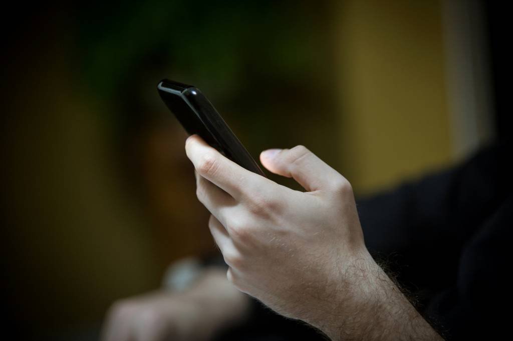 Homem usando celular (DircinhaSW/Getty Images)