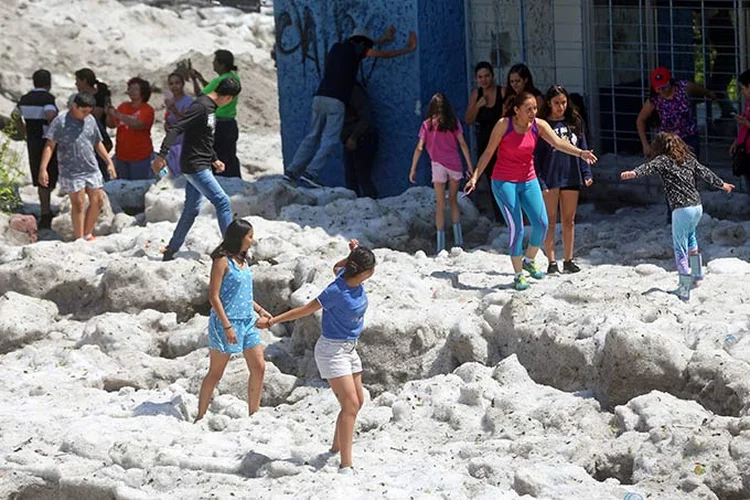 Moradores caminham sobre gelo após tempestade de granizo em Guadalajara, no domingo.  (Fernando Carranza/Reuters)