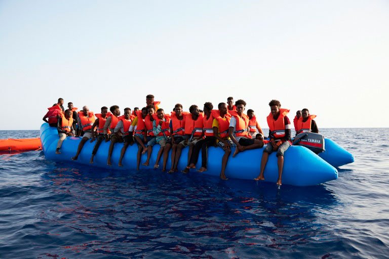 Crise Humanitária: Migrantes a bordo de embarcação na Líbia (AFP/AFP)