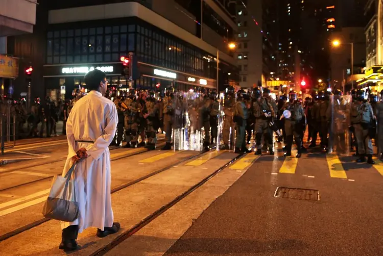 Padre fica na frente da polícia em protesto em Hong Kong, dia 4/8/2019
 (Eloisa Lopez/Reuters)