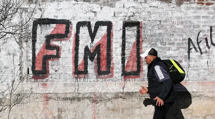 Homem em frente a um grafite com a inscrição da sigla do FMI em Buenos Aires: termina nesta quarta-feira o prazo das conversas entre o fundo e o governo de Fernández (Marcos Brindicci/Reuters)
