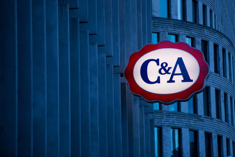 A logo hangs outside a C&amp;A Group fashion clothing store in Berlin, Germany, on Wednesday, Jan. 4, 2017. Germany had another year of firm growth in 2016 and should continue to be propelled in 2017 by consumer spending. Photographer: Krisztian Bocsi/Bloomberg (Krisztian Bocsi/Reprodução)