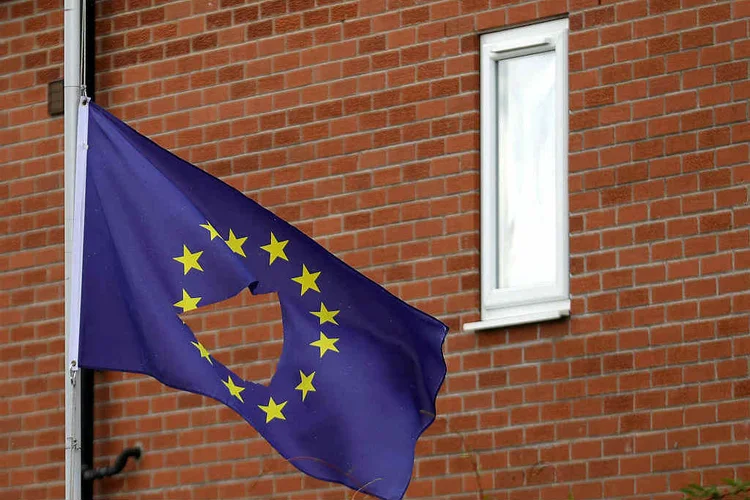 Bandeira da União Europeia com um furo no meio, fazendo alusão à saída do Reino Unido: obstáculos têm afetado as conversas desde o início em março (Christopher Furlong/Getty Images)