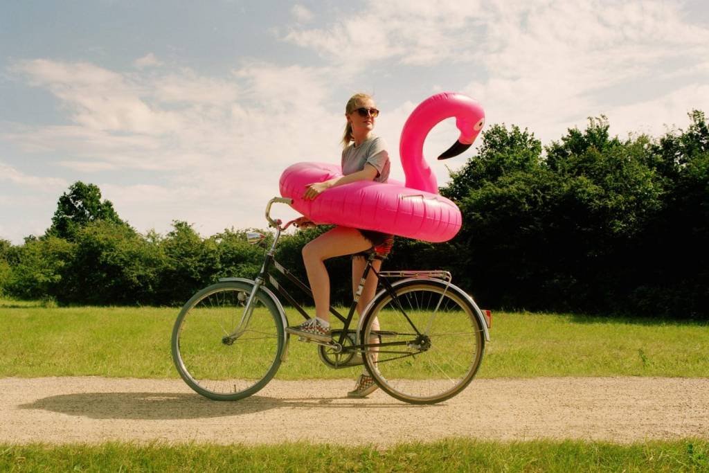 Mulher anda de bicicleta com boia de flamingo
 (Muriel de Seze/Getty Images)