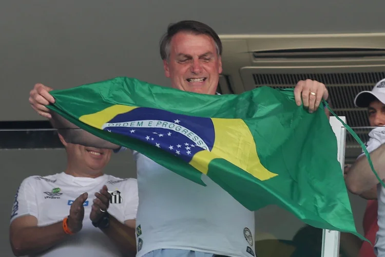 Presidente Jair Bolsonaro segurando bandeira do Brasil durante jogo do Santos e São Paulo, dia 16/11/2019 (Rahel Patrasso/Reuters)