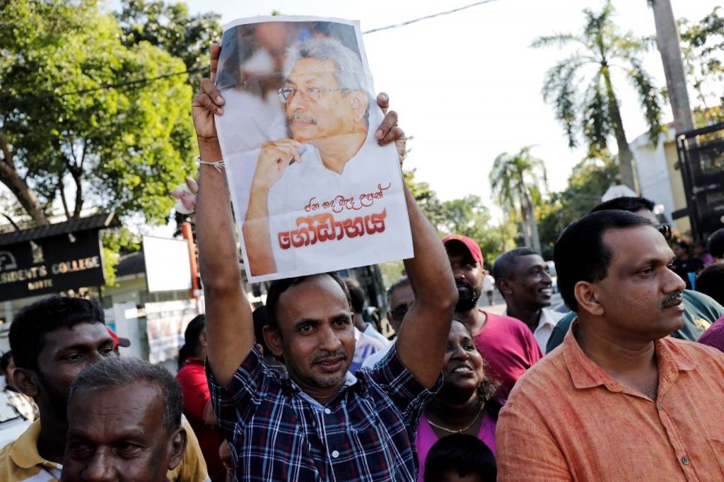 Pessoa com cartaz do presidente Gotabaya Rajapaksa em Colombo, Sri Lanka (Dinuka Liyanawatte/Reuters)