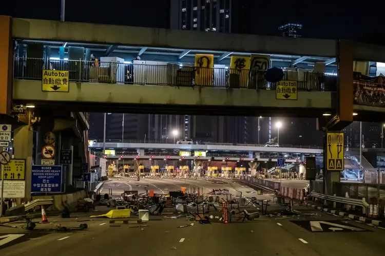 Manifestações: Cadeiras e destroços formam uma barricada em frente a pedágios durante um protesto no túnel Cross-Harbour na área Hung Hom (Justin Chin/Bloomberg)