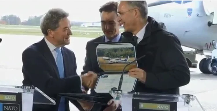 Da direita para a esquerda: O secretário-geral da Otan, Jens Stoltenberg assinou acordo com o presidente da Boeing International, Michael Arthur (EFE/Reprodução)