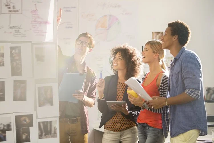 Grupo de jovens no trabalho (Tom Merton/Getty Images)