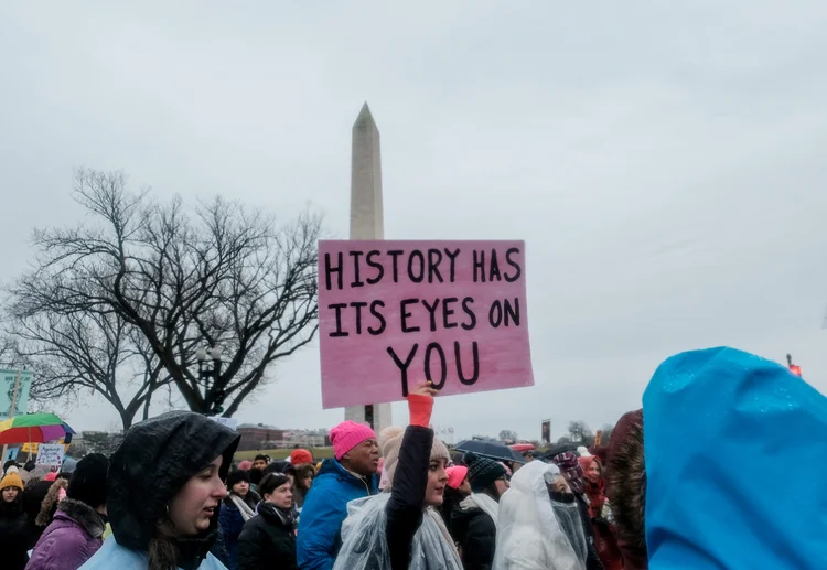 Manifestantes na Marcha das Mulheres 2020, em Washington: "a história está de olho em você", diz o cartaz (Michael A. McCoy/Reuters)
