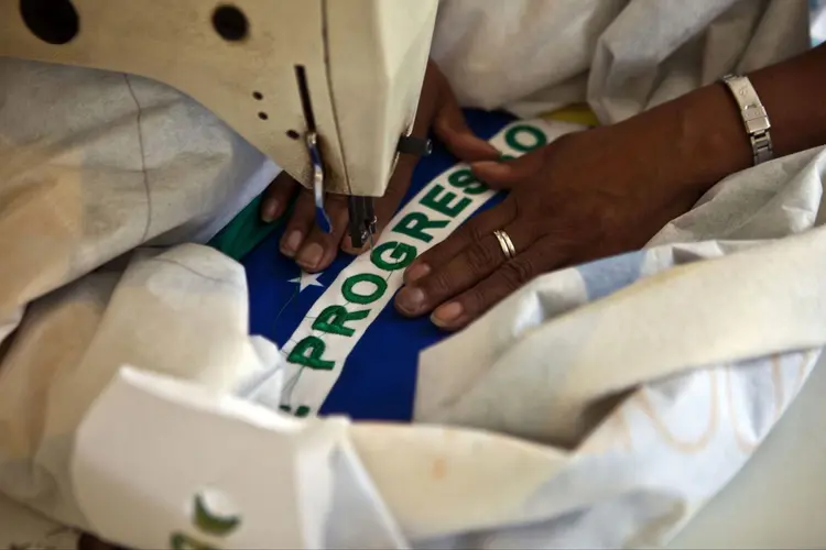 Trabalhadora costura bandeira do Brasil: economia se recupera, mas num ritmo ainda lento (Dado Galdieri/Bloomberg)
