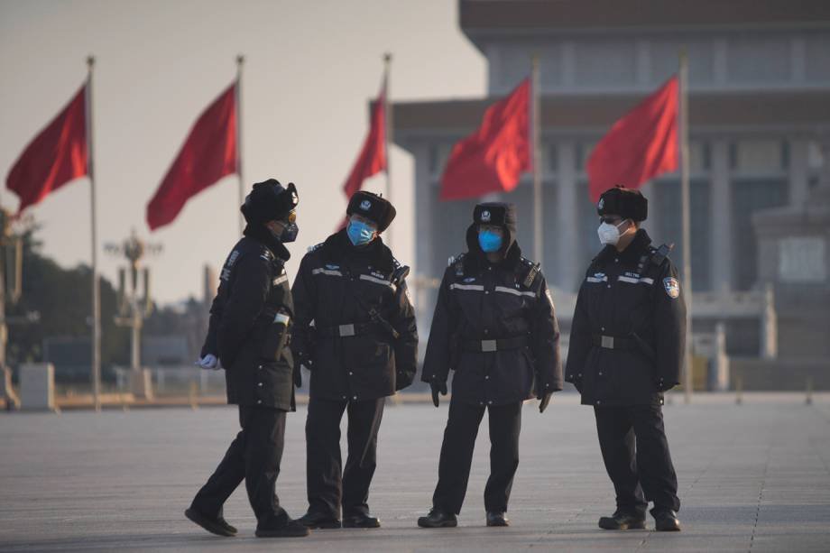 Policiais usando máscaras na Praça da Paz, um dos principais pontos turísticos de Xangai, na China