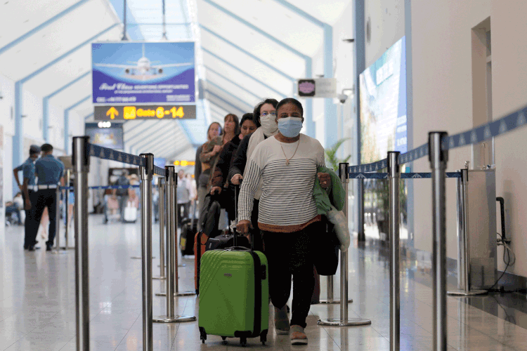 Pessoas usam máscaras em aeroporto: aéreas permitem adiar viagens para a China e a Itália até junho (Dinuka Liyanawatte/Reuters)