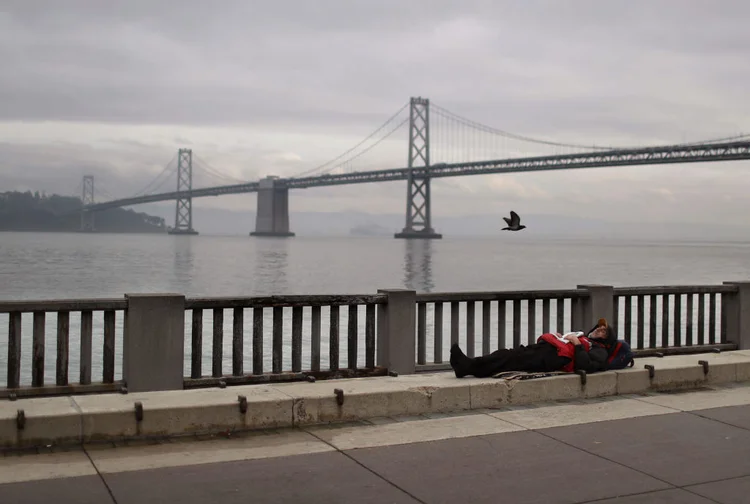 Morador de rua em frente à ponte que liga São Francisco a Oakland: governo quer construir albergues de emergência em terrenos públicos (Justin Sullivan/Getty Images)