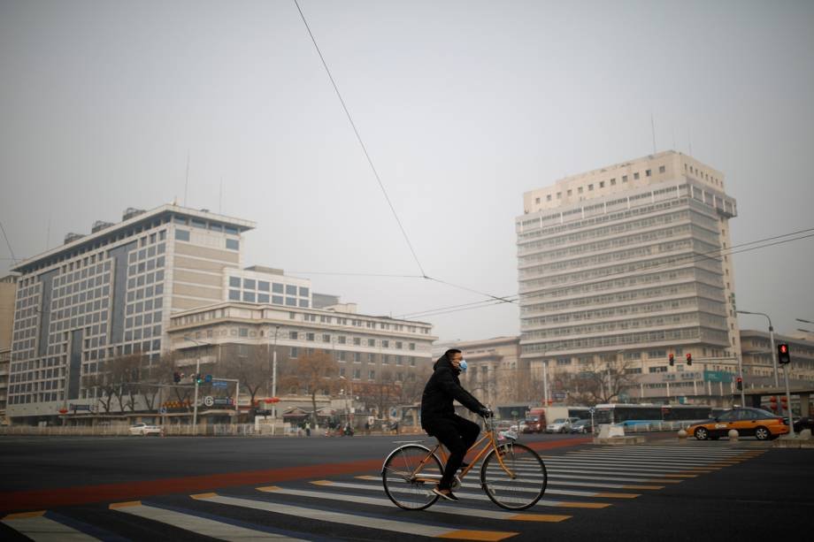 Homem anda de bicicleta em Pequim, na China