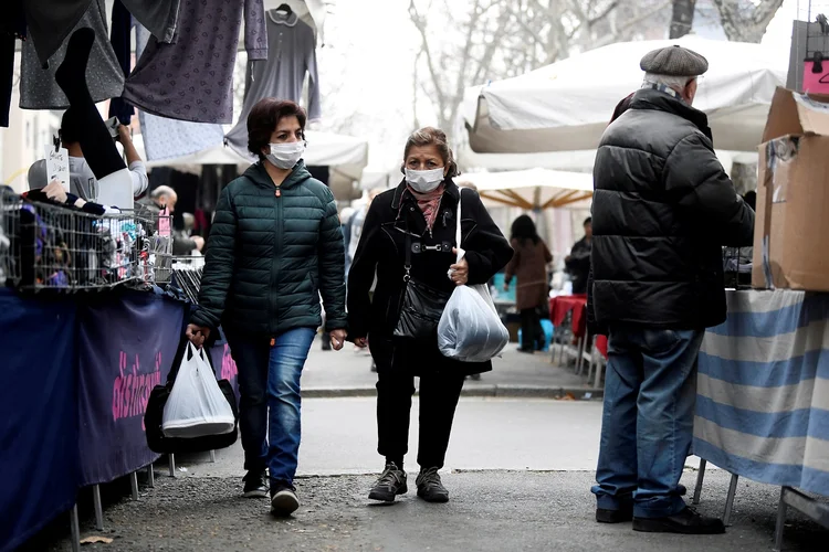 Pessoas com máscaras em Milão, na Itália: principal companhia aérea da Bulgária, Bulgaria Air cancelou todos os voos para Milão até 27 de março (Flavio Lo Scalzo/Reuters)
