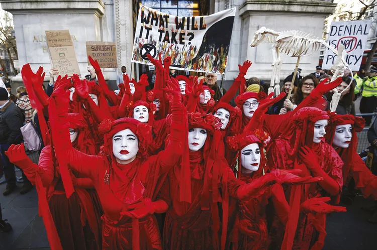 Protesto contra o aquecimento global em Londres (à esq.) e manifestantes do movimento #MeToo, em Nova York
 (Henry Nicholls/Reuters)