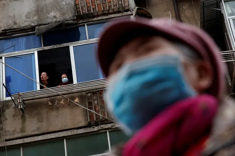 Chineses usando máscaras: mais de 20.000 casos de coronavírus confirmados (Thomas Peter/Reuters)