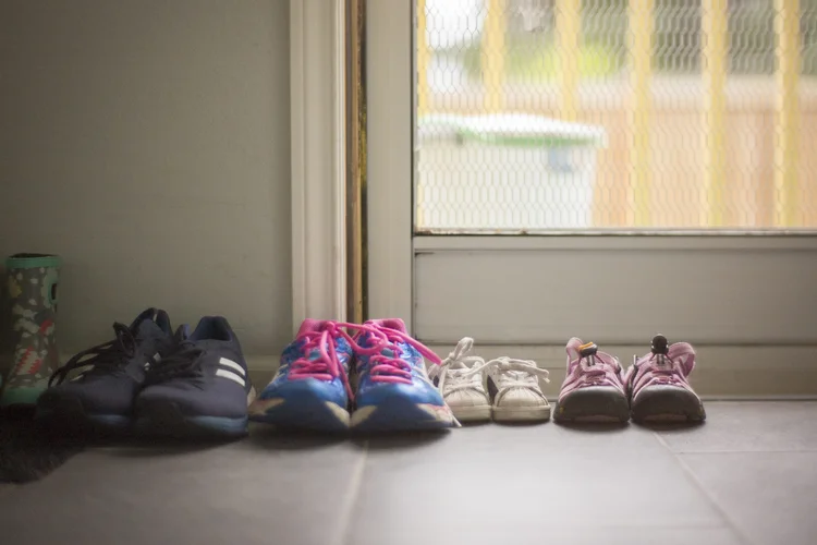 Foto de sapatos de uma família ao lado da porta. Foto: William Andrew / Getty Images (William Andrew/Getty Images)