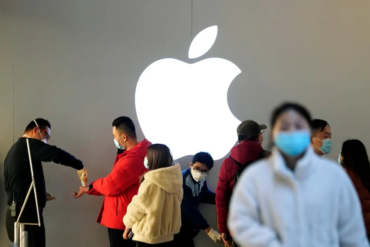 Apple: pessoas usando máscaras de proteção esperam para medir sua temperatura numa loja da marca (Aly Song/Reuters)