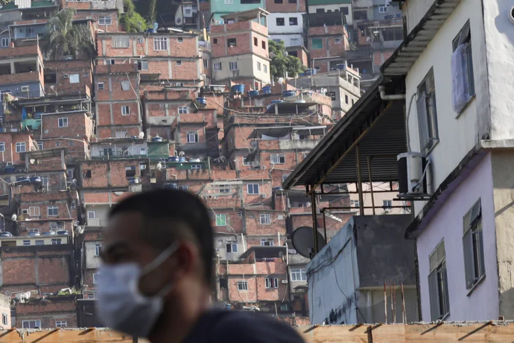 Coronavírus: Homem passa pela favela da Rocinha (RJ) usando máscara de proteção. Março de 2020.  (Ricardo Moraes/Reuters)