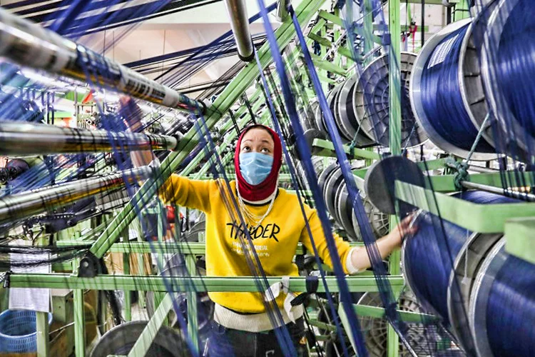 Funcionário de fábrica chinesa trabalha com máscara de proteção: Produto Interno Bruto pode voltar a crescer de 2% a 3% no 2º trimestre à medida que fábricas aumentam a produção (China Daily/Reuters)