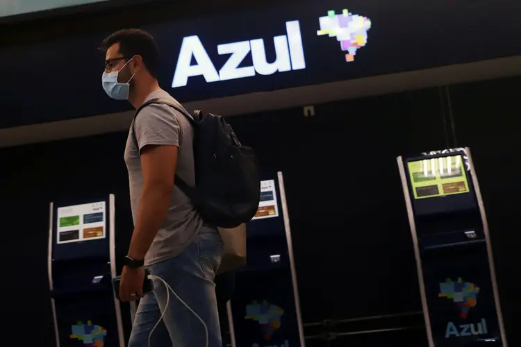 Passageiros usam máscara em frente a galpão da Azul: setor aéreo é um dos mais vulneráveis a impactos da pandemia (Rahel Patrasso/Reuters)