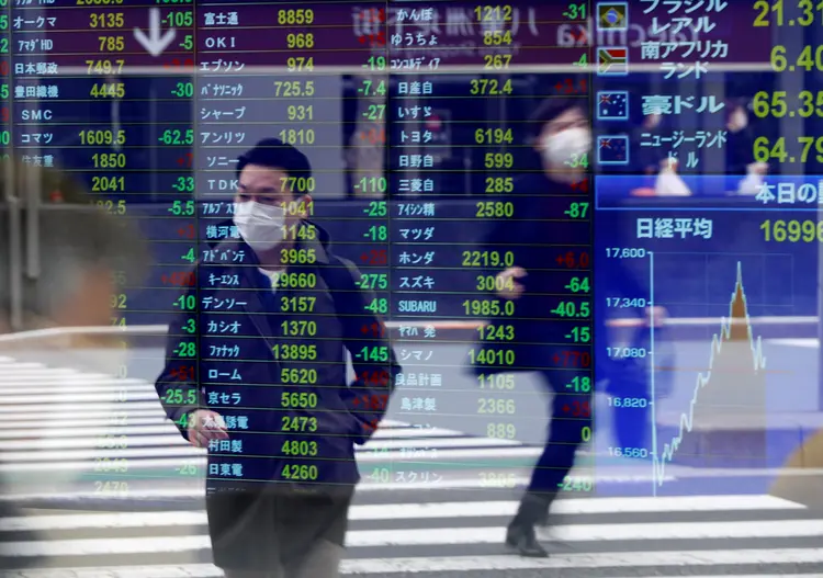 Bolsa de valores e pessoas com máscara contra o coronavírus (Issei Kato/Reuters)