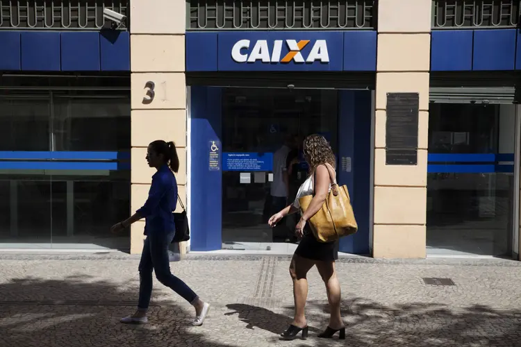 Aug. 31, 2015 - Pedestrians pass the Cinelândia branch of the Caixa Economica Federal in downtown Rio de Janeiro. The Caixa is a government-owned bank that has a monopoly on providing pawn loans in Brazil. (Nadia Sussman/Getty Images/Getty Images)