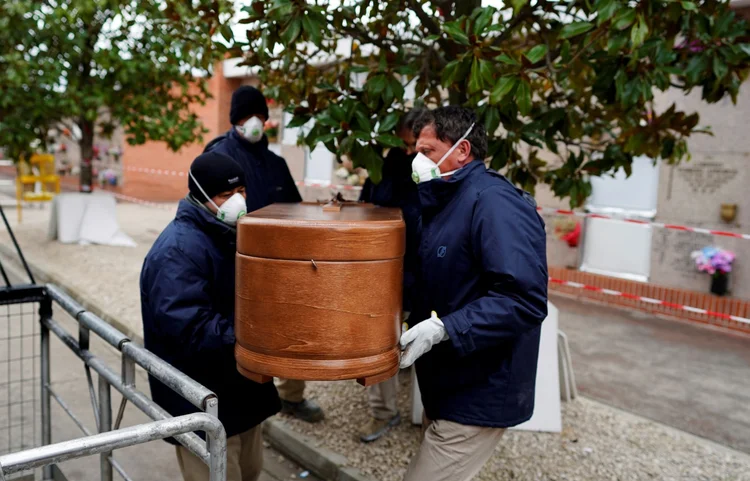 Caixão sendo carregado em Madri: no total, são mais de 70 mil contaminados e 6 mil mortos no país (Juan Medina/Reuters)