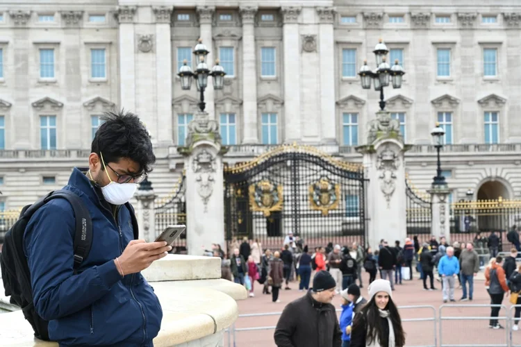 Pessoas usam celular para acessar redes sociais: influenciadores digitais postam mais conteúdos que o habitual em momento de quarentena em diversos países do mundo (Foto/AFP)