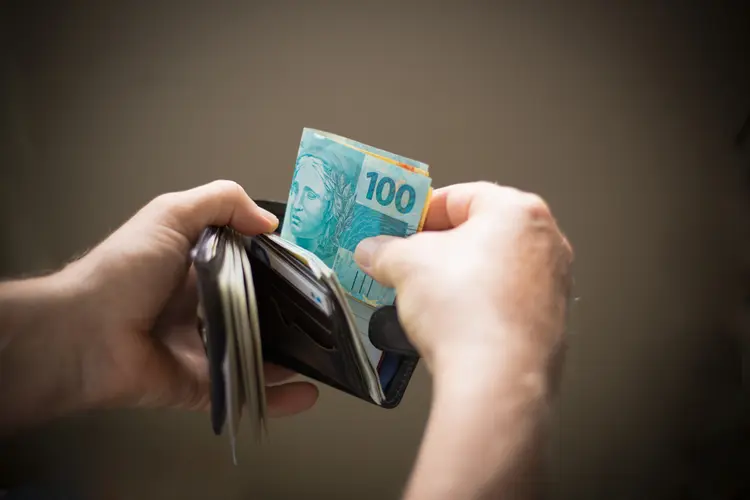 Hands catching  brazilian money from the wallet. (DircinhaSW/Getty Images)