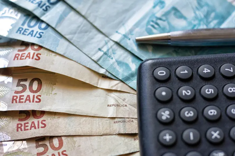 Finance Concept - Calculator, Brazilian Money and Pen (Gustavo Mellossa/iStock/Getty Images)