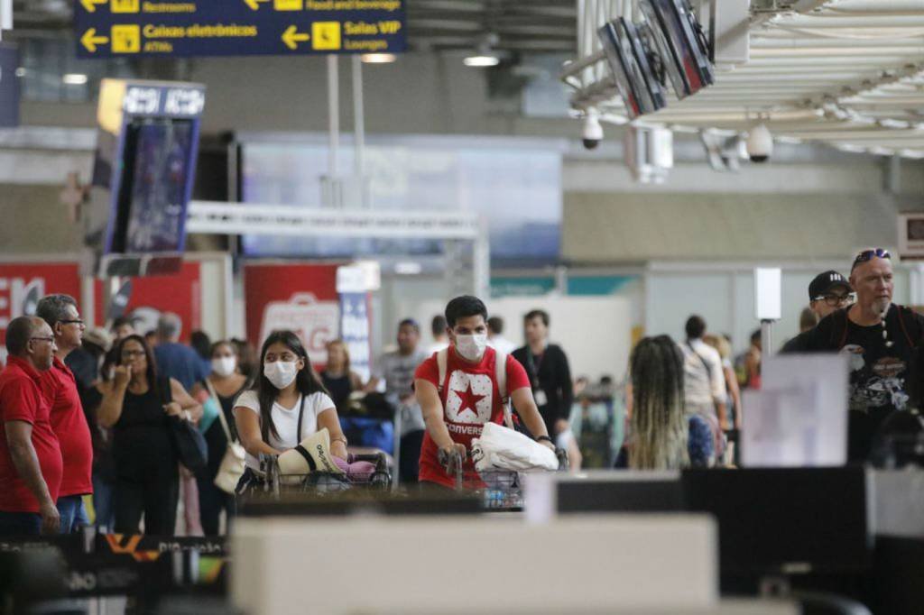 Pessoas usam máscara em aeroporto no Brasil: higienizar as mãos e evitar tocar o rosto são algumas das dicas para prevenir o contágio do novo coronavírus (Fernando Frazão/Agência Brasil)