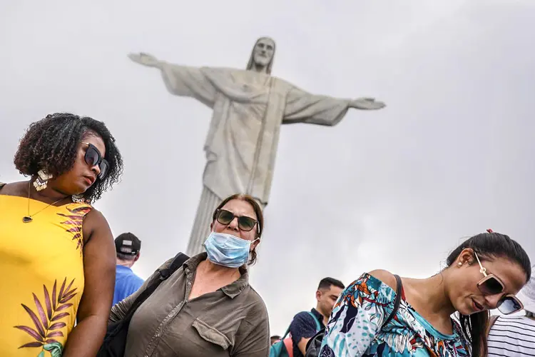 Pessoas com máscaras no Rio de Janeiro: pesquisadores observaram recentemente que o uso de máscaras reduzia a quantidade de coronavírus expirados pelos pacientes (Pilar Olivares/Reuters)