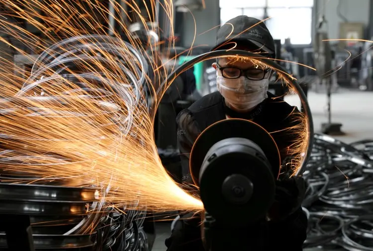 Empregado com máscara em fábrica: empresas afirmam que funcionários usam proteção a todo o tempo (China Daily/Reuters)