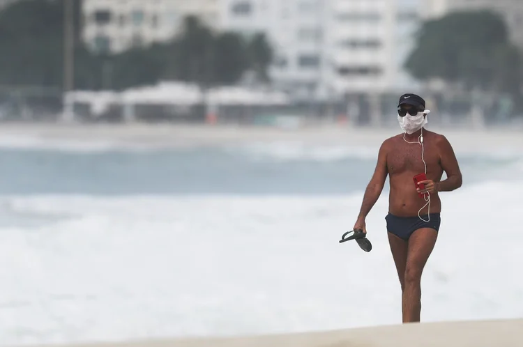 Pessoa com máscara em praia: cidade está em segundo lugar no número de casos (Sergio Moraes/Reuters)