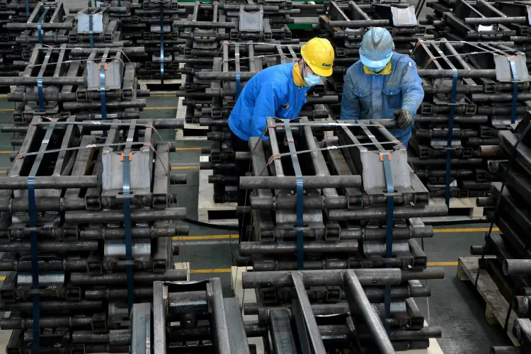 Chineses trabalham em linha de produção usando máscaras, em Taizhou, Jiangsu. 28 de março de 2020. (China Daily via/Reuters)