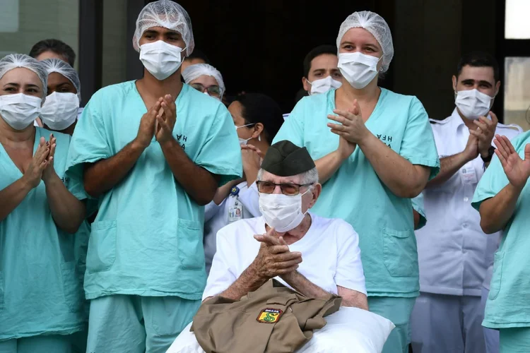 Ermando Armelino Piveta: o ex-combatente sai do hospital usando um chapéu militar e máscara de proteção e prestou continência enquanto era aplaudido pela equipe médica (Foto/AFP)