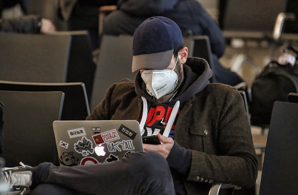 Coronavírus: homem usando o computador em aeroporto e usando máscara de rosto (Valery Sharifulin / Colaborador/Getty Images)