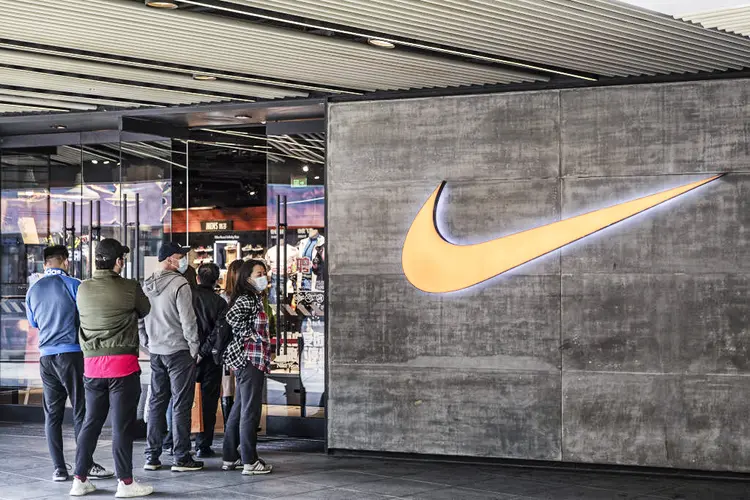 Consumidores usam máscaras de proteção em frente de loja da Nike na China (Qilai Shen/Bloomberg/Getty Images)
