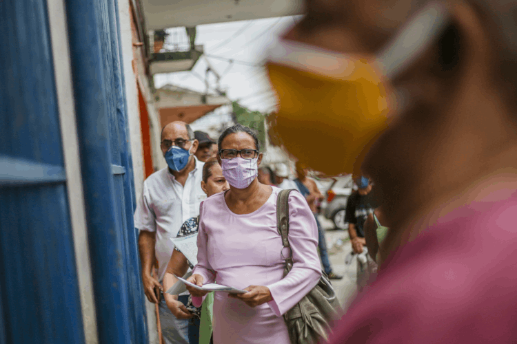 Pessoas de máscaras: velocidade de crescimento é chamada de incidência e é medida de acordo com o número de novos casos por dia (Bloomberg / Colaborador/Getty Images)