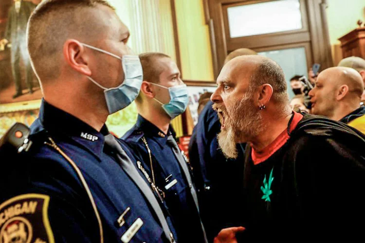Contra a quarentena: Manifestantes tentam entrar na Câmara dos Deputados de Michigan (Jeff Kowalsky/AFP/Getty Images)