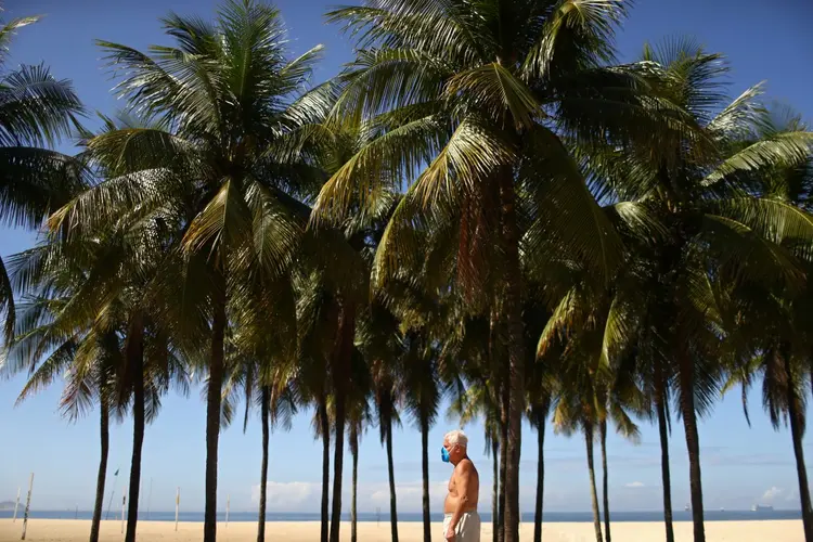 Homem caminha de máscara na orla do Rio de Janeiro: distanciamento social é maneira mais eficiente de reduzir contágio do coronavírus (Pilar Olivares/Reuters)