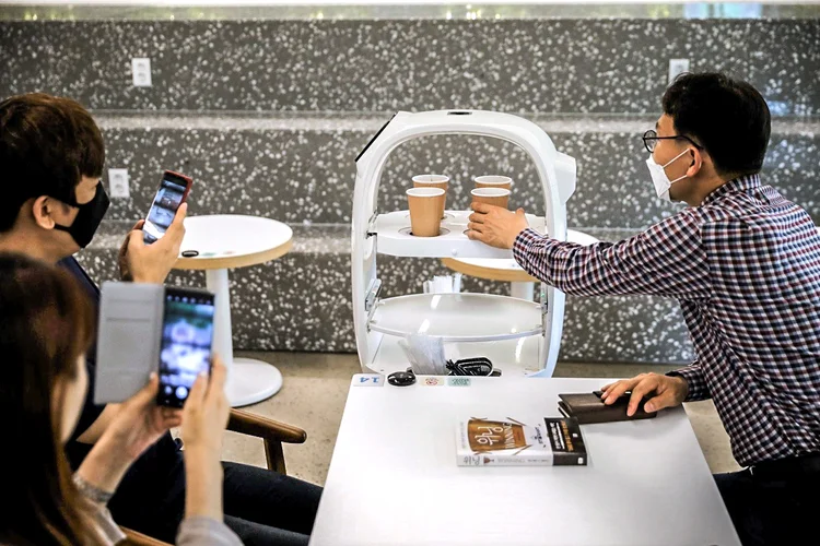 Robô que serve cafés: Coreia do Sul está lentamente migrando do intenso distanciamento social para o que o governo chama de "distanciamento na vida diária (Kim Hong-Ji/Reuters)