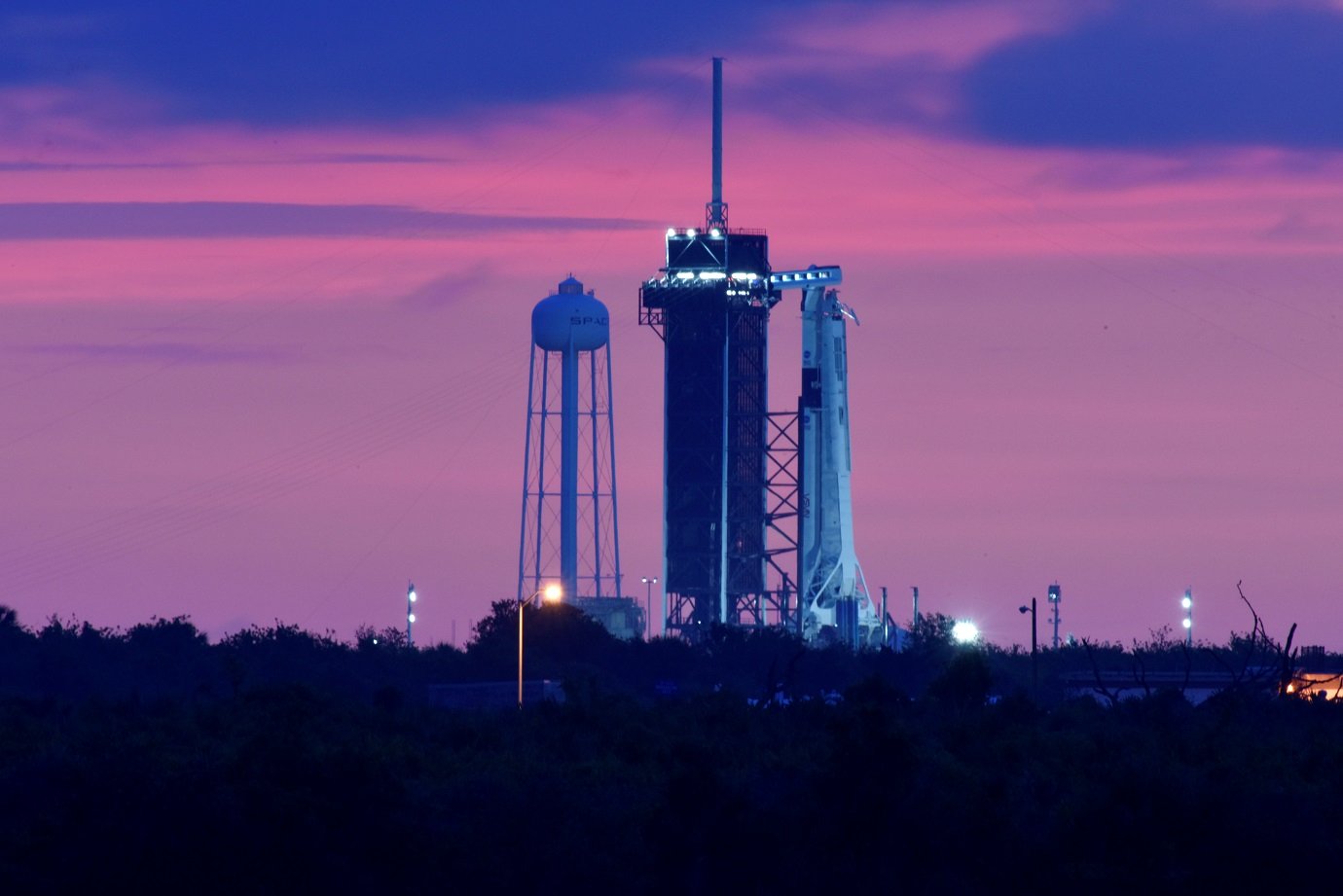 Foguete Falcon 9 e Crew Dragon na plataforma ao anoitecer