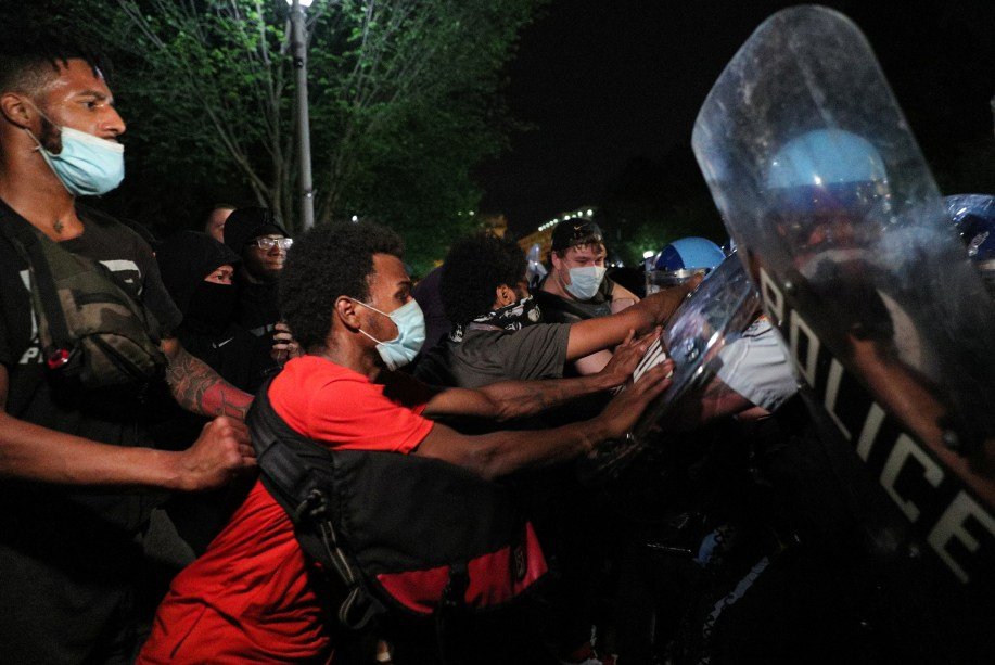 Manifestantes usando máscaras de proteção enfrentam policiais durante manifestação contra morte de George Floyd, em Washington, EUA, em 30 de maio de 2020. REUTERS / Tom Brenner