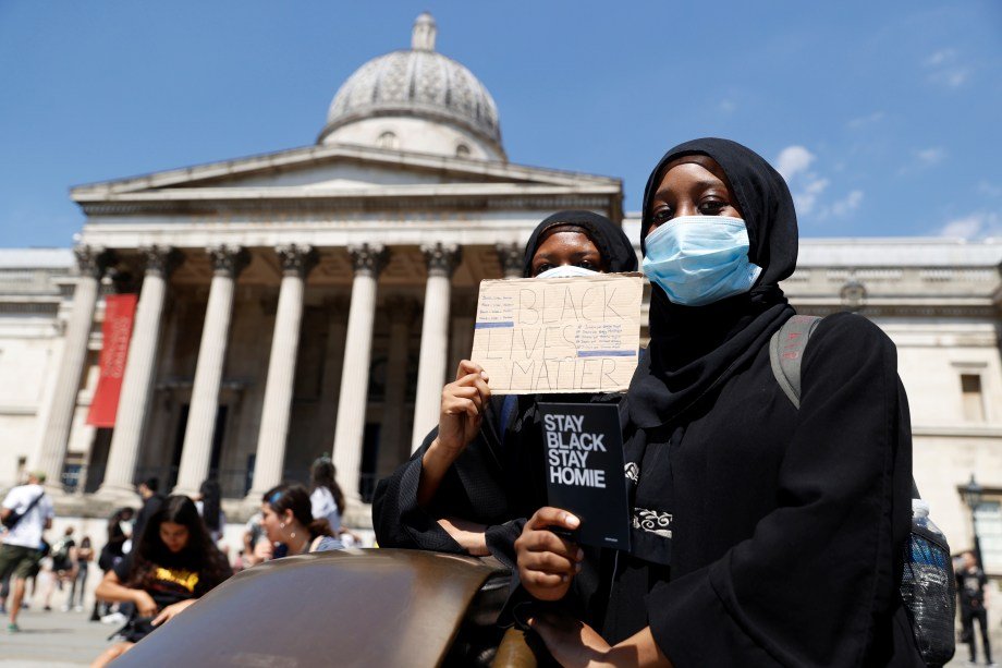 Mulher de máscara de proteção durante  protesto contra a morte de George Floyd, na Trafalgar Square, em Londres. 31 de maio.  REUTERS/John Sibley