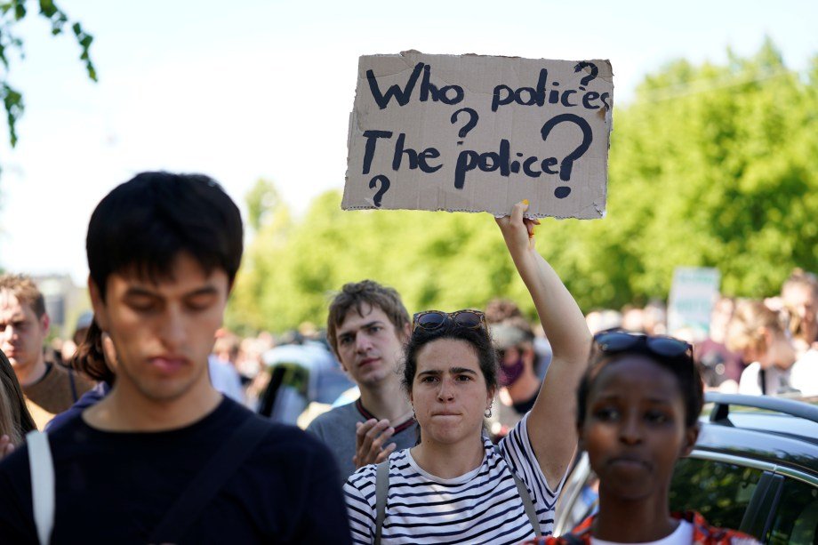 Manifestante com cartaz dizendo "quem policia a polícia" durante ato contra a morte de Gerge Floyd. 31 de maio. Ritzau Scanpix/Ida Guldbaek Arentsen via REUTERS